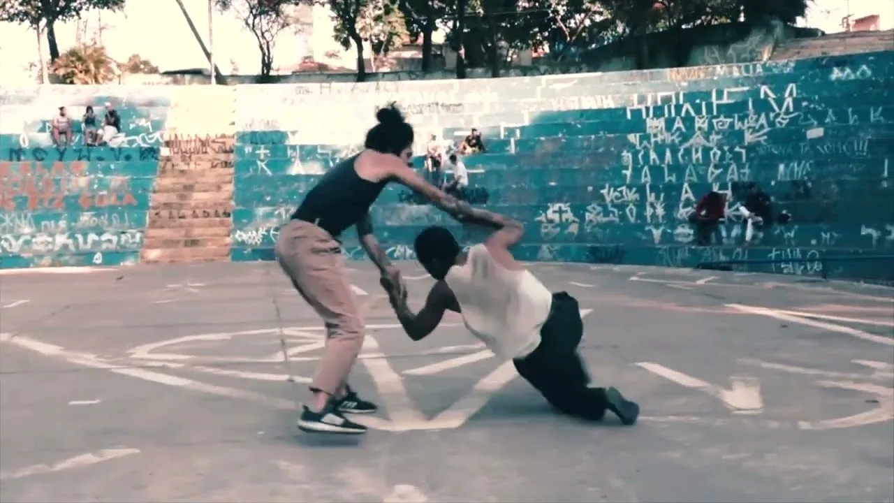 Koide Ura e Lee Anderson dançam juntos em uma quadra aberta